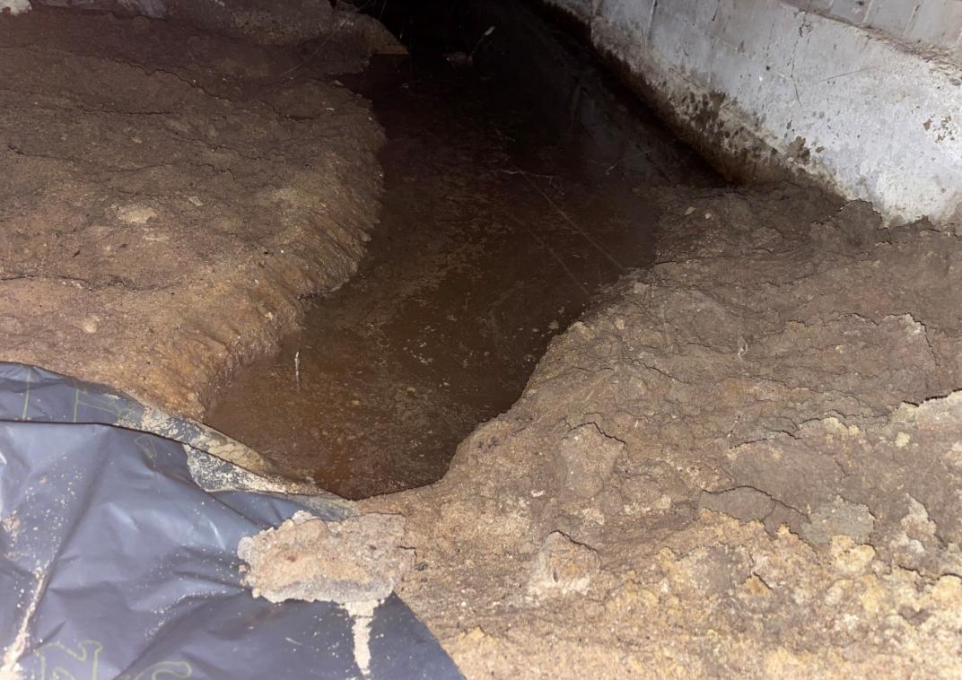 Grondwater opgevangen in een geul in de kruipruimte om erger te voorkomen