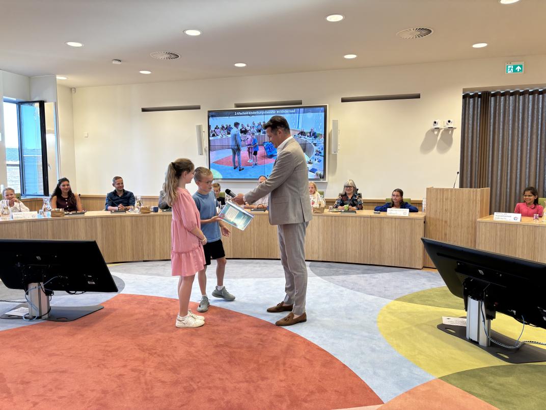 Kinderraadsleden boden de adviezen van de kinderraad aan aan wethouder Visser